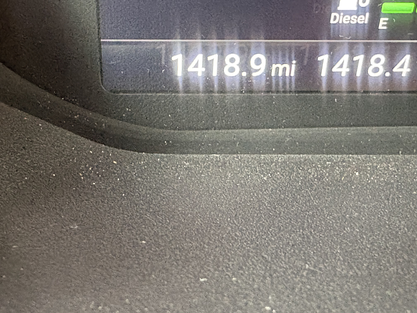 Truck dashboard display showing 1418.9 miles and 1418.4 miles on the odometer with diesel indicator.