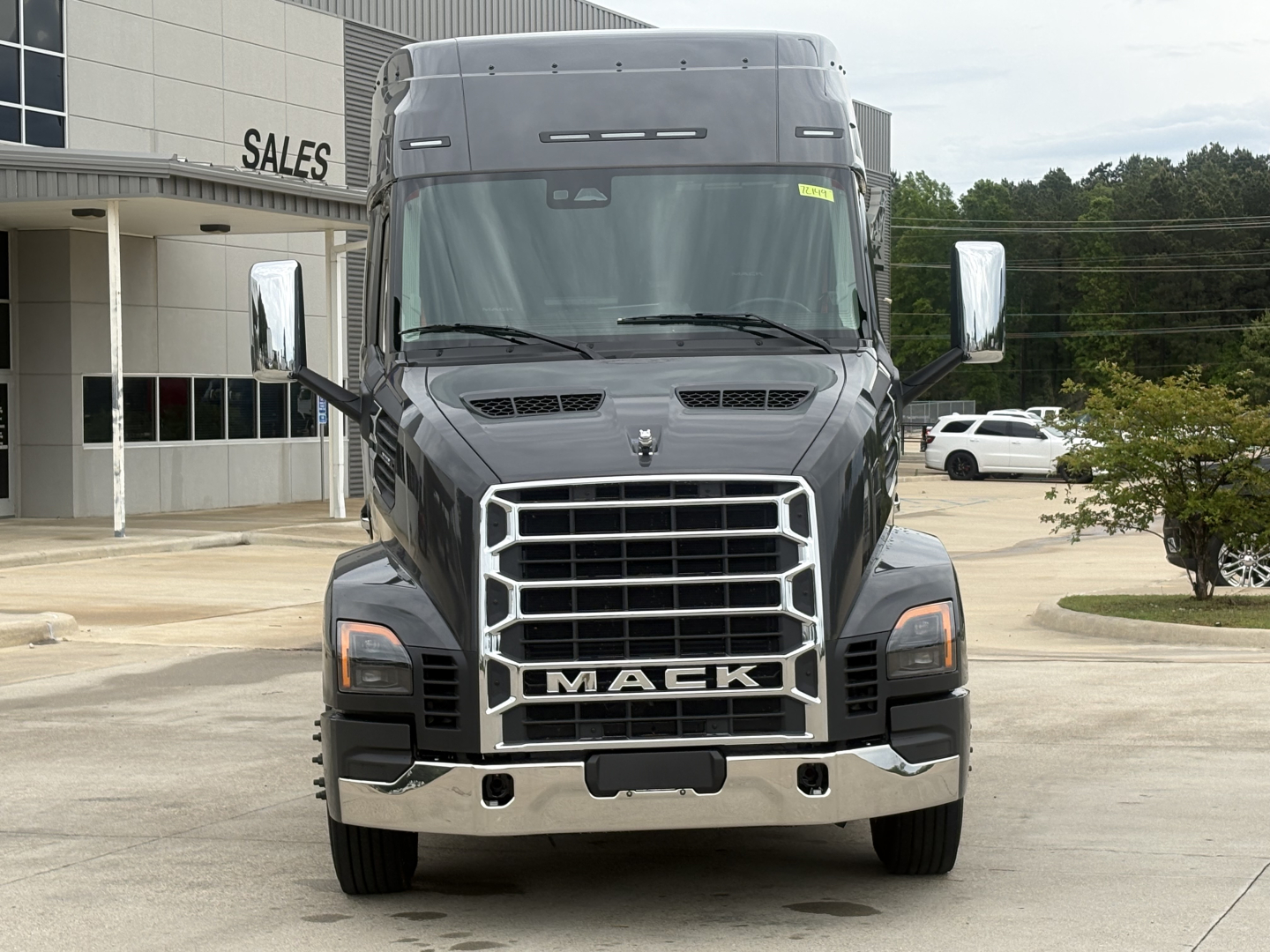 Mack AN64T64 conventional daycab truck front view with large grille and chrome bumper. Visible text includes MACK on grille. No other legible labels visible.