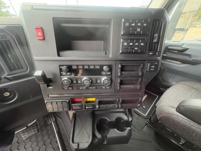 Mack AN64T64 dash area showing center console with climate controls, switches, cup holders and storage compartments.