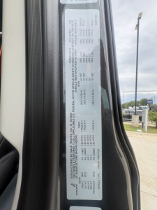 Label with vehicle specs inside door jamb for Mack AN64T64 with VIN 1M1A24GY9VM102527 and stock 72149.