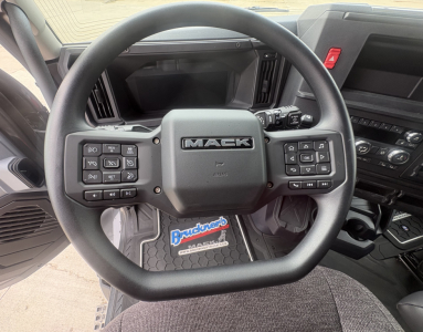 Mack AN64T64 truck interior steering wheel with dashboard controls and Bruncrop? floor mat showing Mack logo.