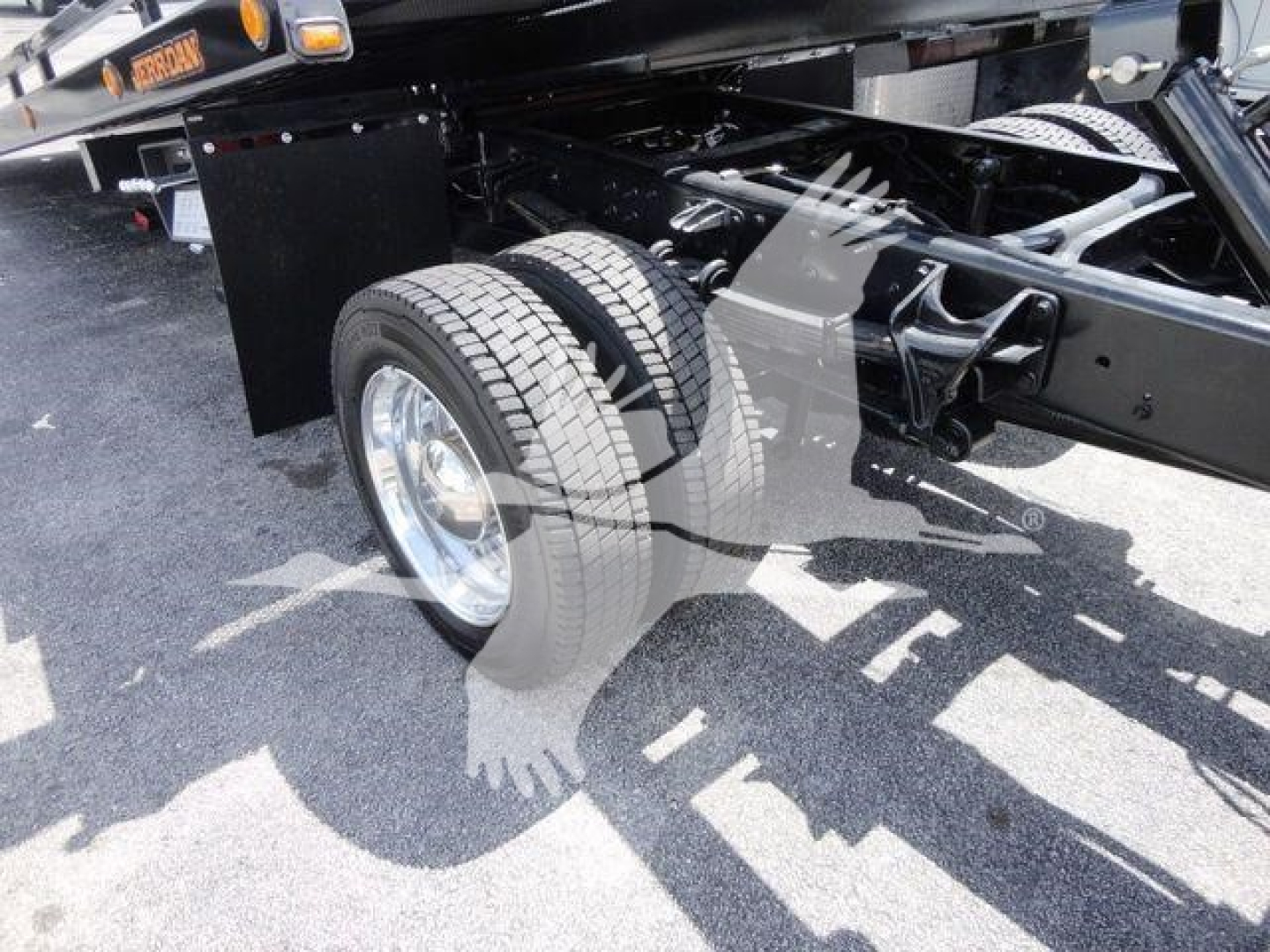 Truck chassis and front wheel area of a 2023 International CV rollback truck showing dual rear wheels, frame, and suspension components.