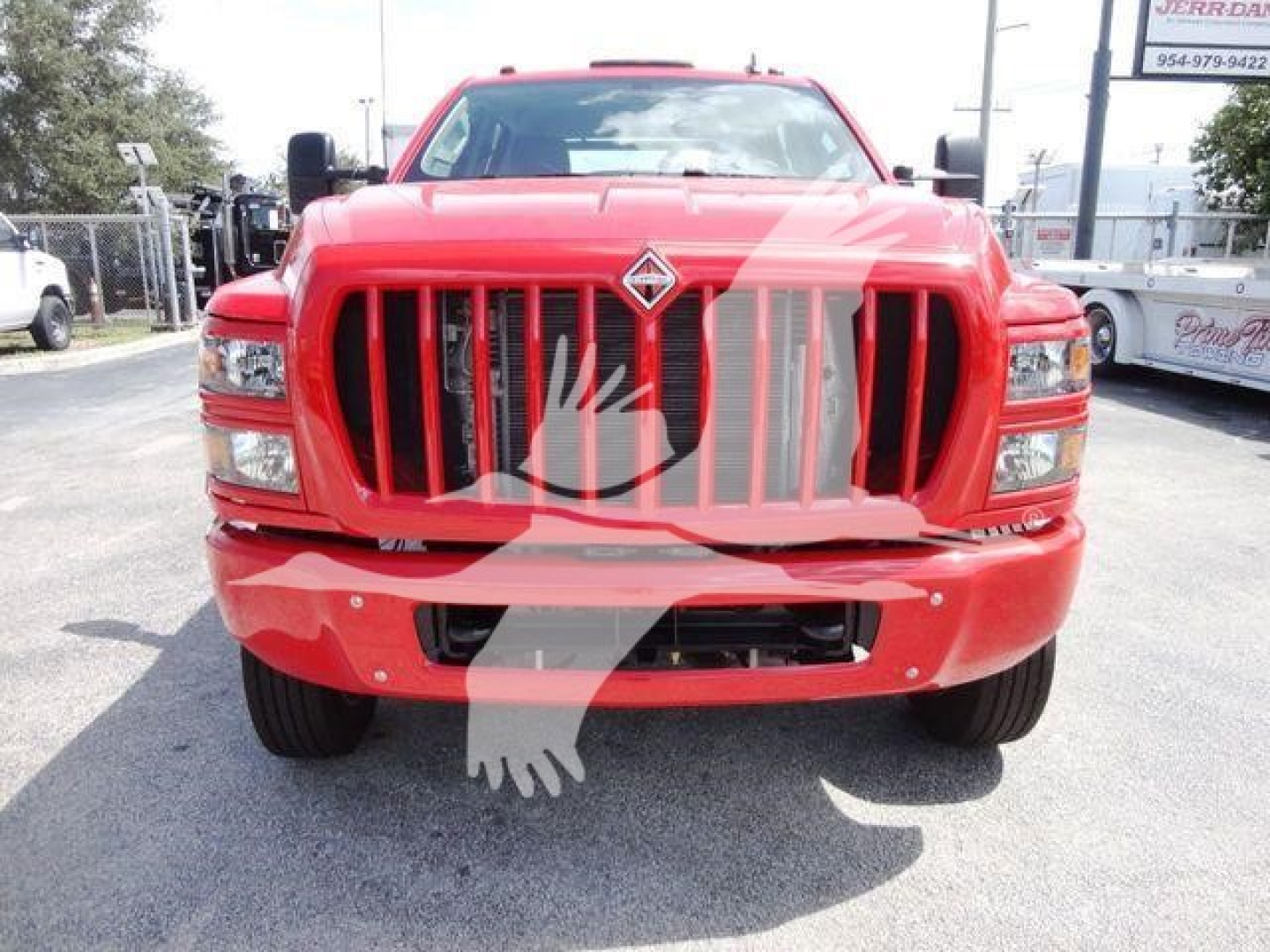 Front view of a red 2023 International CV rollback truck with a large vertical grille and diamonds logo. The image shows the front bumper, headlights, and grille.