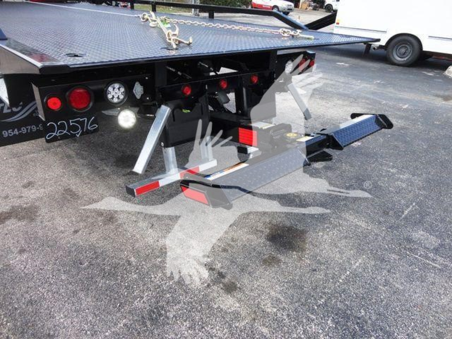 International rollback truck rear with hydraulic wing and stabilizers, lights, and metal platform; visible stock number 22516 and service area.