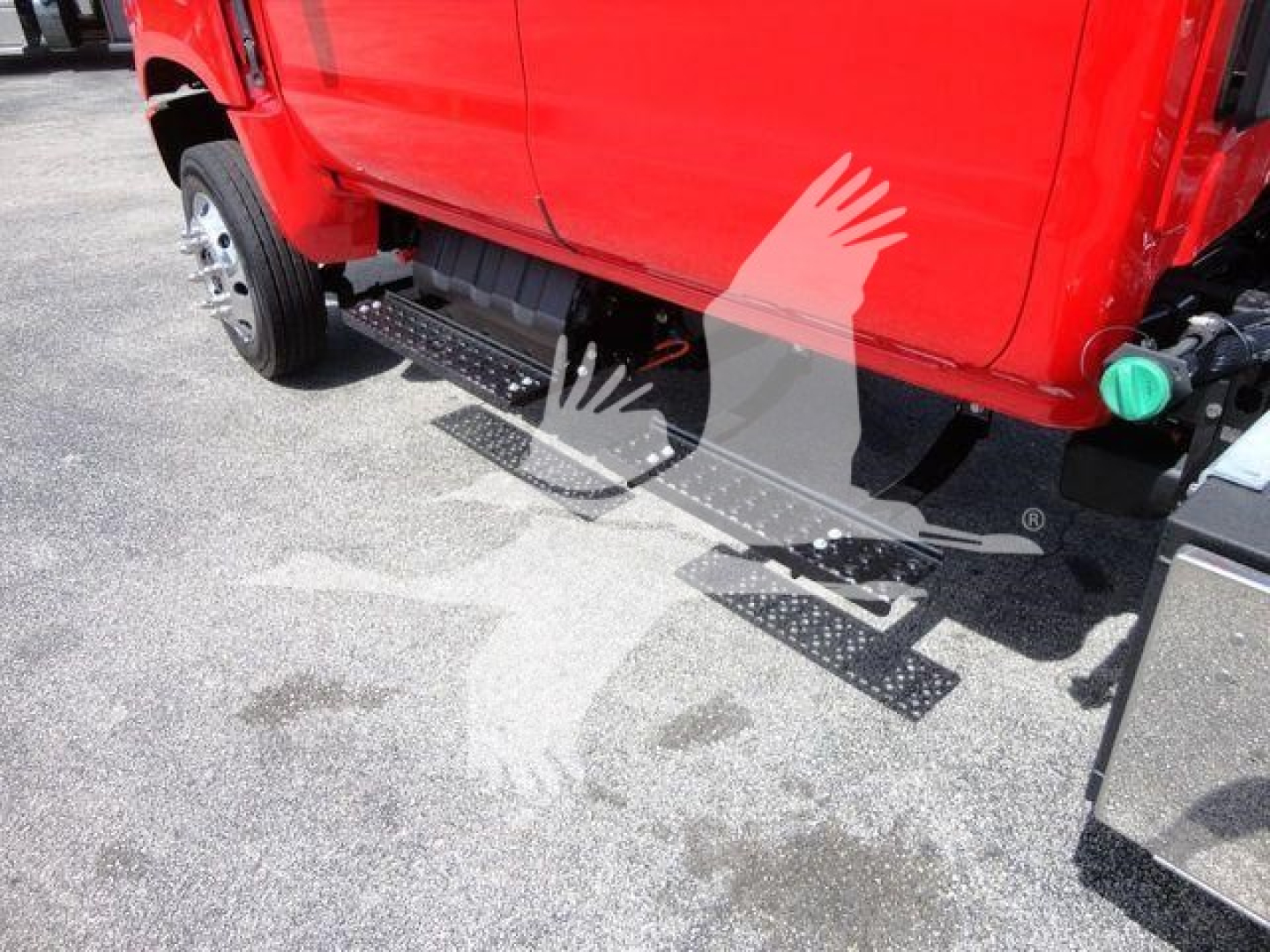 Truck side view showing metal side steps/rails beneath a red International CV cab.