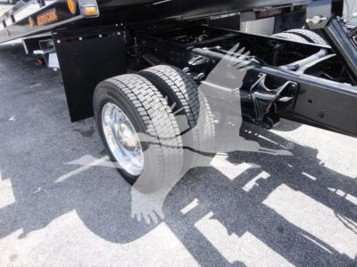 Truck chassis and front wheel area of a 2023 International CV rollback truck showing dual rear wheels, frame, and suspension components.