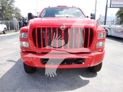 Front view of a red 2023 International CV rollback truck with a large vertical grille and diamonds logo. The image shows the front bumper, headlights, and grille. 