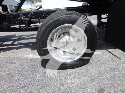 Trucks chassis with front wheel and hub showing; steel rim and tire, underside of frame visible.