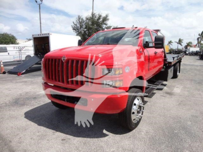 International CV truck in red on rollback body with front grille and side mirrors visible.