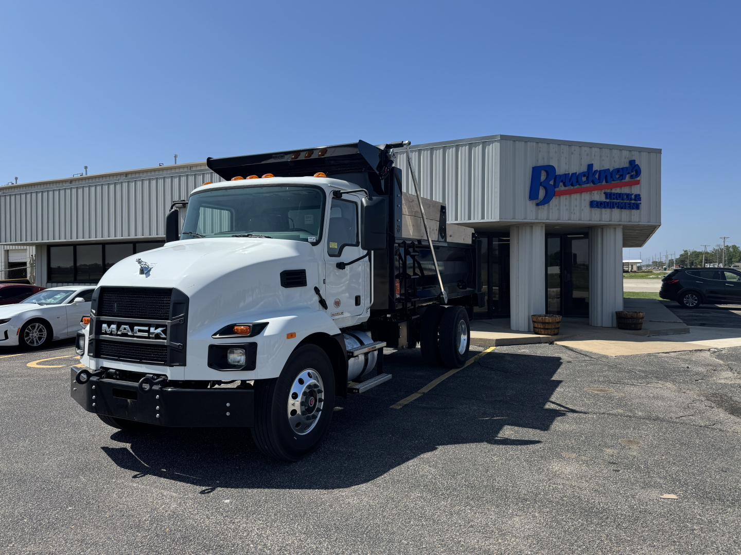 Mack MD7 dump truck in front of dealership building with Bracken's sign.