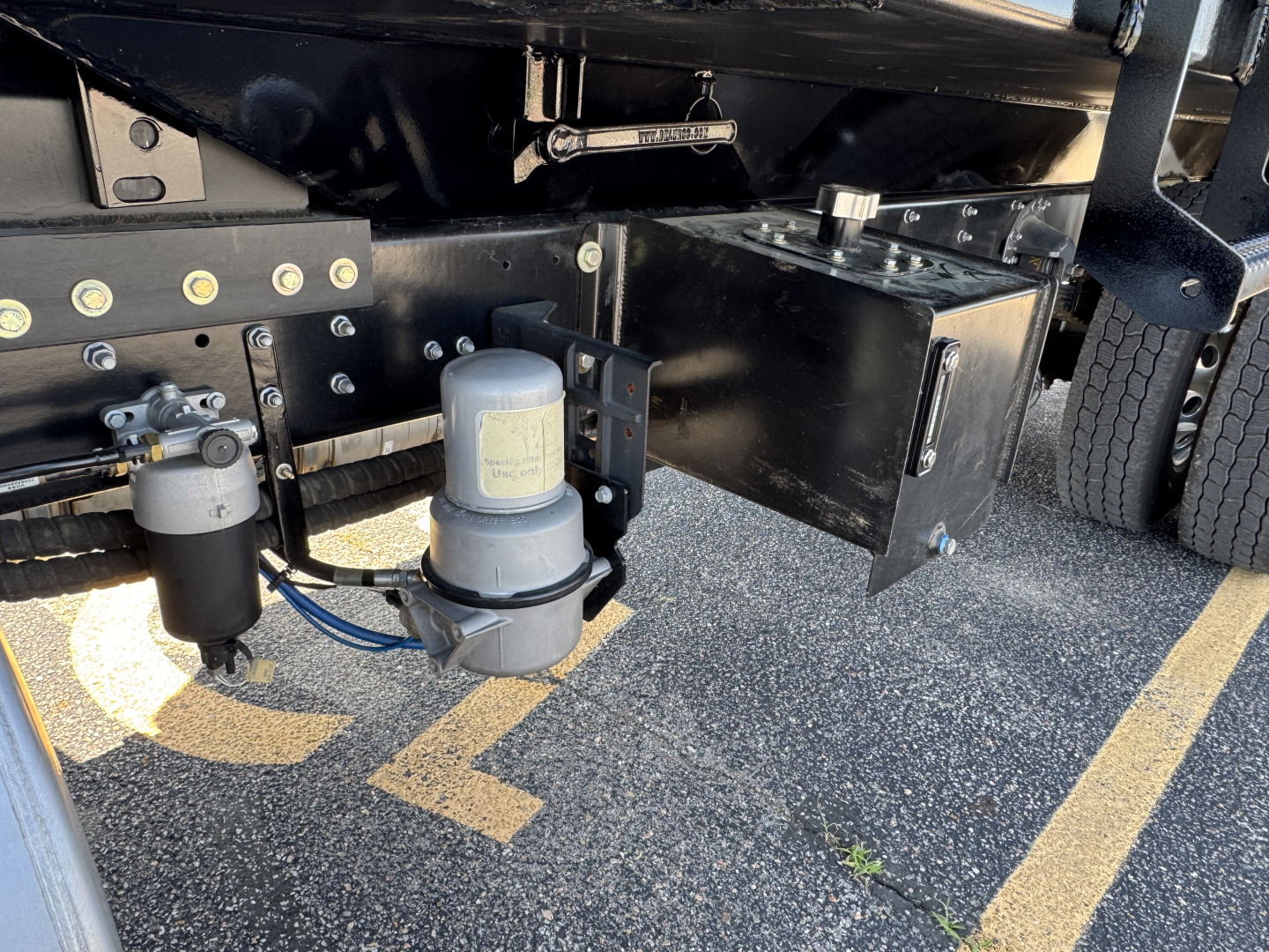 Mack MD7 truck undercarriage showing two cylindrical fluid filters and metal frame components.