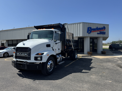 Mack MD7 dump truck in front of dealership building with Bracken's sign.