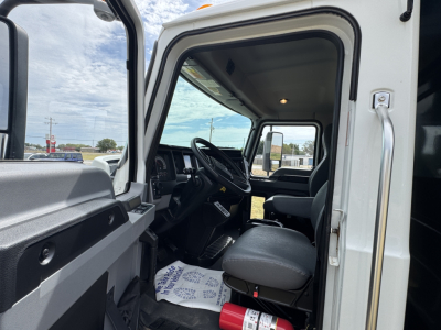 Mack MD7 truck cab interior showing driver seat and steering wheel from open door.