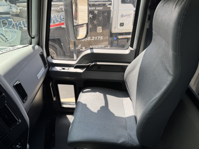 Truck cab interior showing driver's seat and dashboard in a Mack MD7 truck.