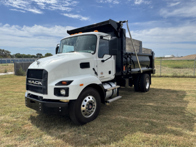Mack MD7 dump truck showing front and left side, white cab, black grille, and dump bed with hydraulic hoist.