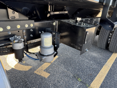 Mack MD7 truck undercarriage showing two cylindrical fluid filters and metal frame components.