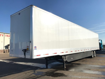 Utility trailer with a white exterior, side view showing plain panel walls, black undercarriage, and dual rear wheels; no legible branding or text on the side visible.