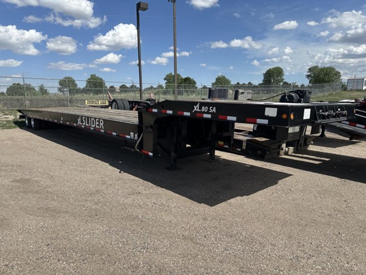 XL Specialized 40 Ton Slide Axle Recovery Trailer in-service showing flatbed with SLIDER branding and wheel chocks.