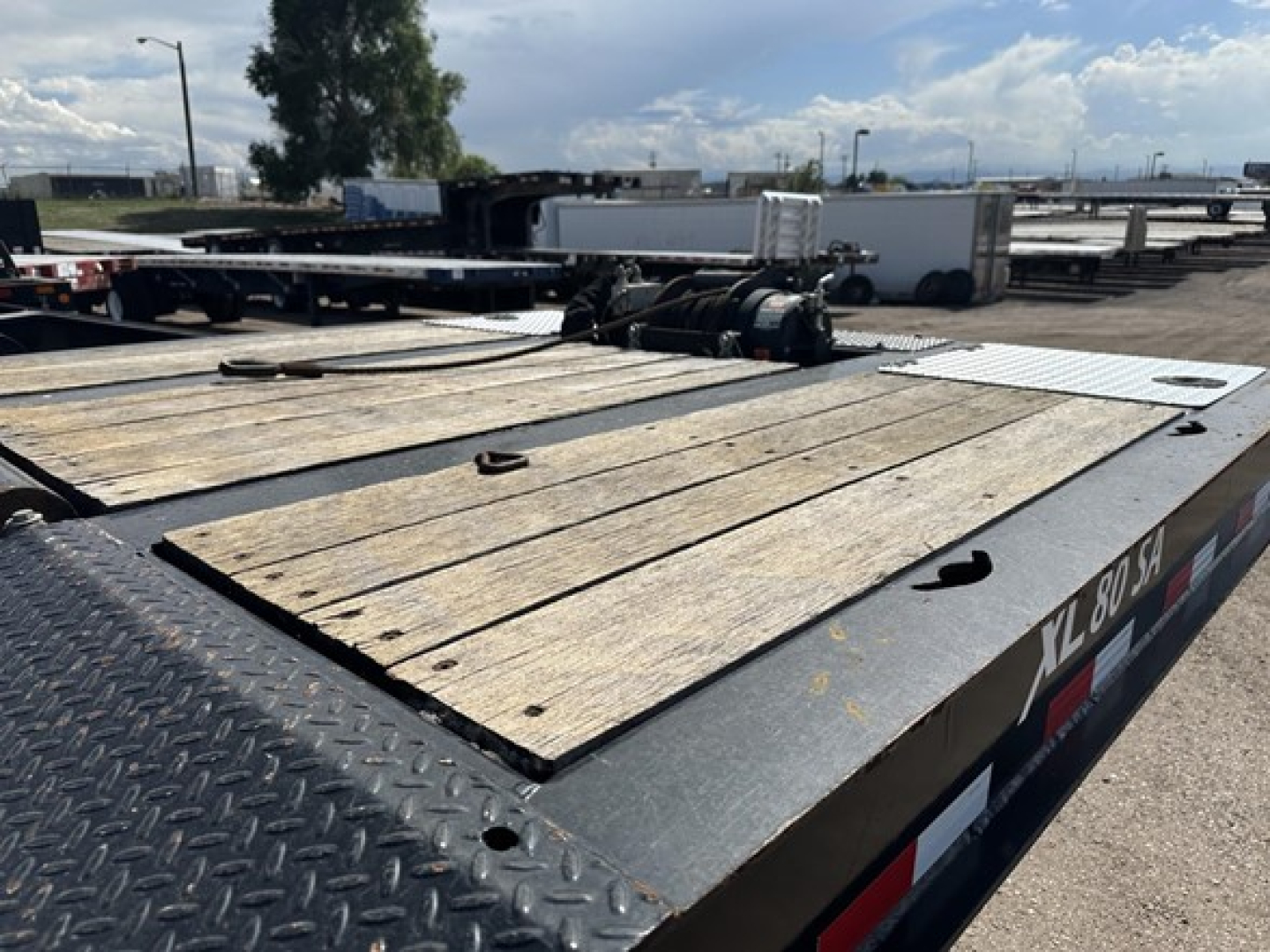 Trailer deck with wooden planks and wheel hubs on XL Specialized 40 Ton slide axle recovery trailer showing metal diamond plate edges.