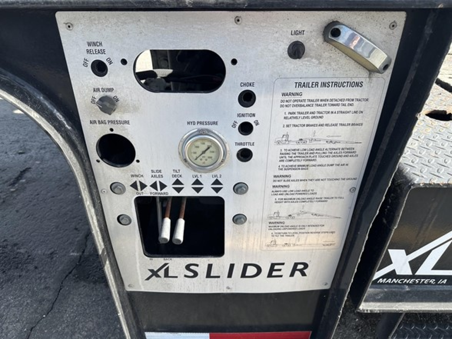 XL Specialized 40 Ton Slide Axle Recovery Trailer control panel with gauges, switches, and labels showing trailer instructions and 'XLSLIDER' branding.