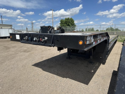 Trailer with 40 ton slide axle recovery equipment. Side controls and hoses visible, black flatbed trailer with ramps and reflectors.