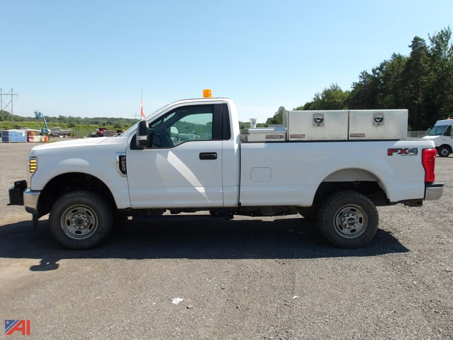 Side view of a white 2019 Ford F-250 Super Duty pickup truck with utility bed, single cab, long wheelbase, orange beacon on cab roof, and FX4 badge.