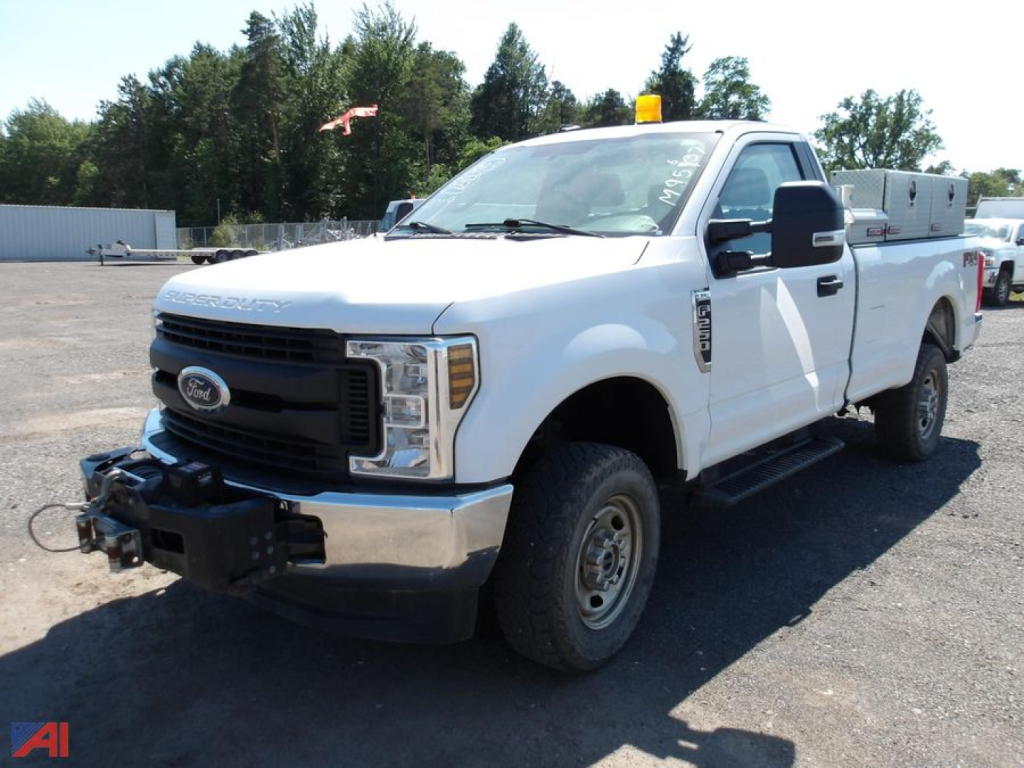 Ford F-250 Super Duty pickup truck 2019, white, extended cab, 4x4, with utility toolbox in bed and front hitch; side view.