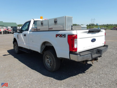 Ford F-250 Super Duty pickup truck in white with FX4 off-road package badge, aluminum toolbox on bed, viewed from rear-left side.