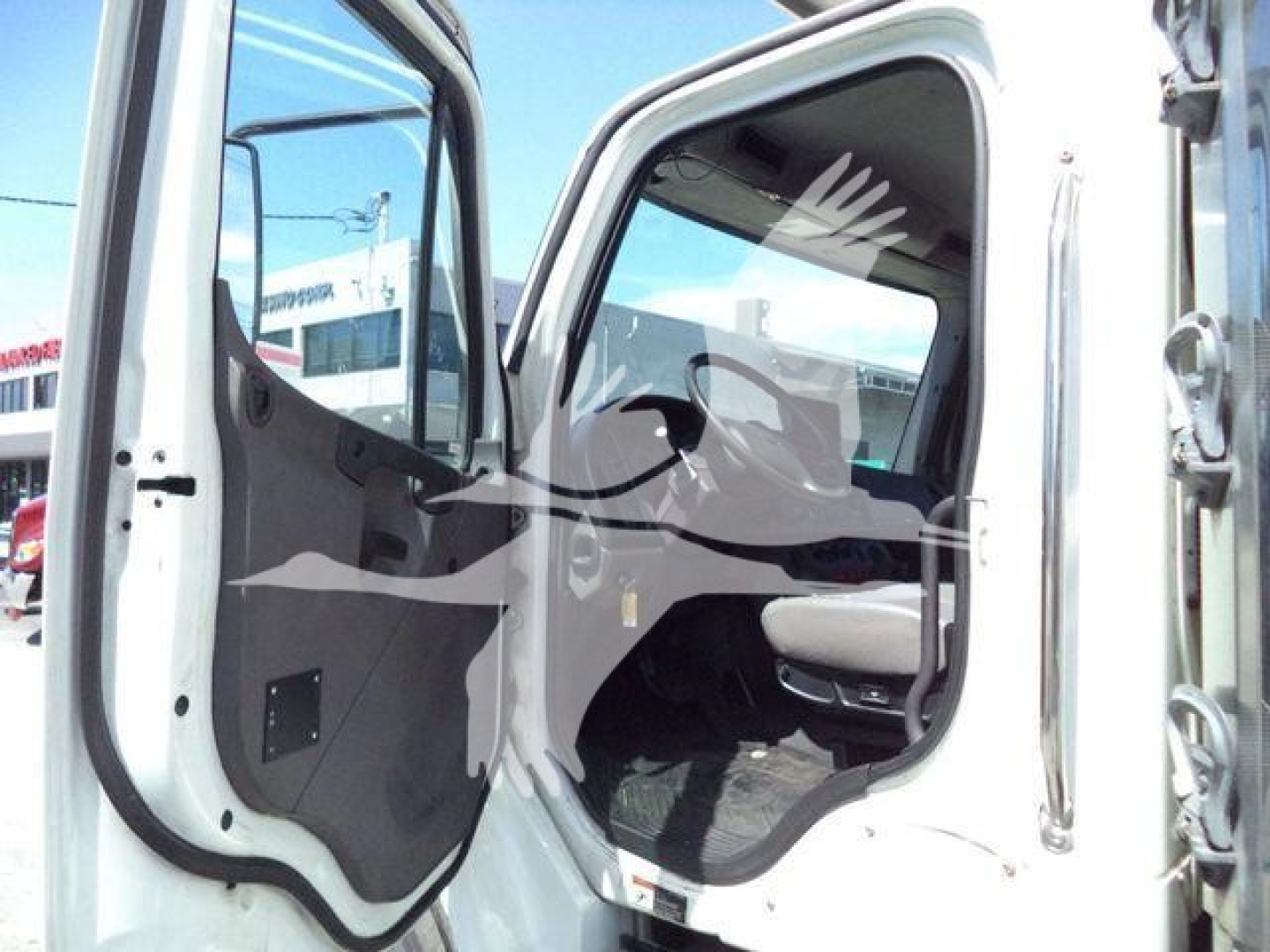 Truck cab interior view of a 2019 Freightliner M2 106 refrigeration unit showing open driver door and dashboard area.