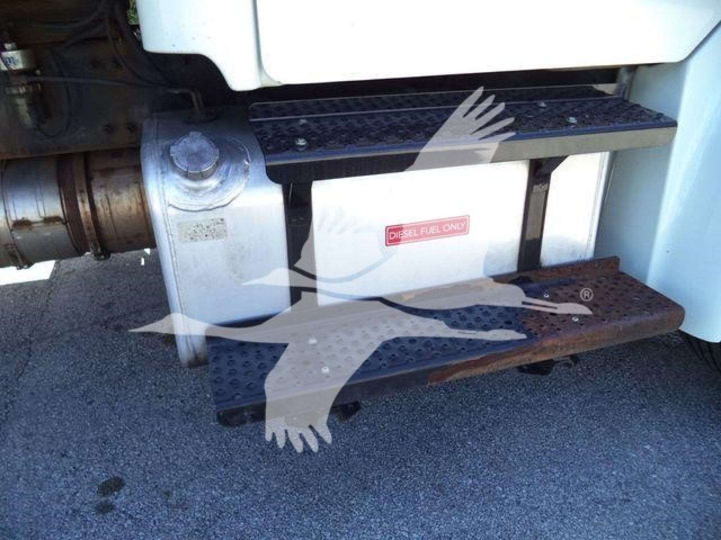 Truck side view showing diesel fuel tank and metal steps on Freightliner M2 106 with walkable steel steps and a label near the tank.