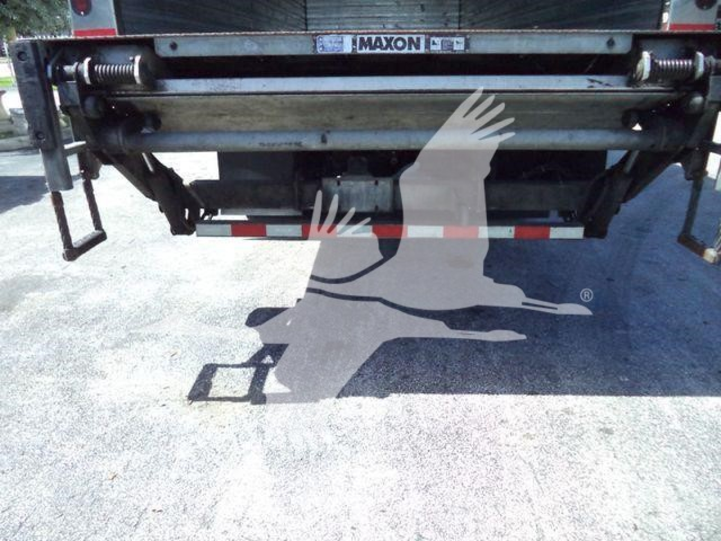 Rear view of a refrigerated Freightliner M2 106 truck showing Maxon liftgate and underbody components.