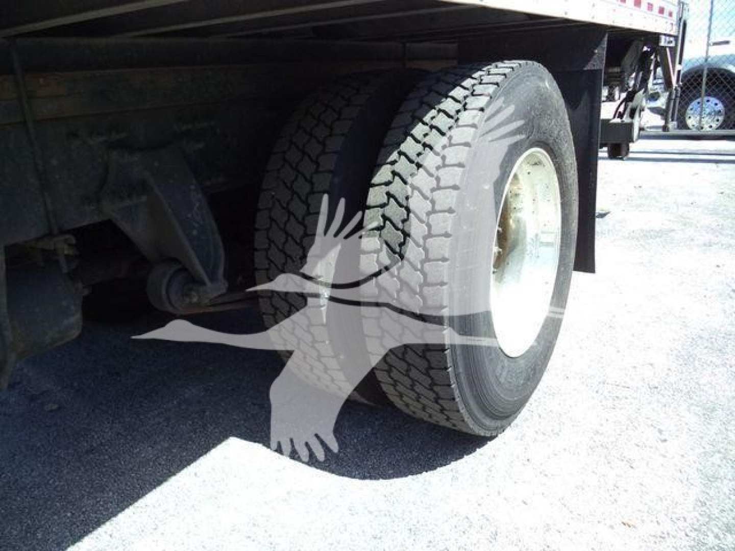 Rear wheel and undercarriage of a Freightliner M2 106 truck showing dual rear tires and suspension components.