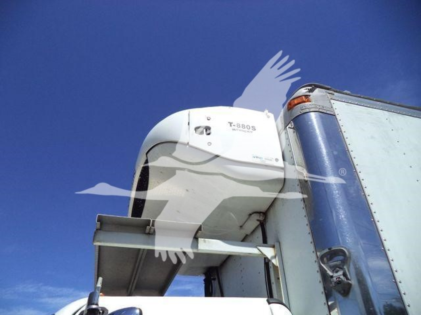 Truck refrigeration unit on Freightliner M2 106 cab with blue cargo trailer side visible.