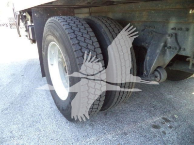 Rear dual wheels of a Freightliner M2 106 truck showing dual tires and suspension undercarriage.