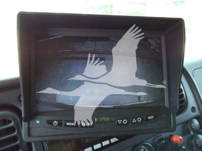 In-cab monitor showing a freight and flight logo on screen in Freightliner M2 106 dashboard area.