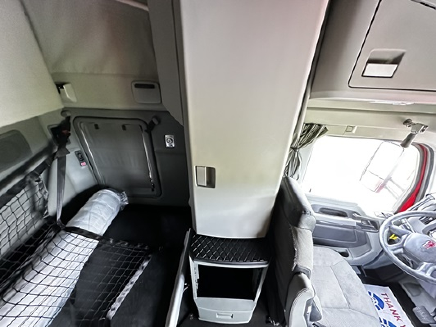 Kenworth T680 truck cab interior showing sleeper area and central storage with cabinet.