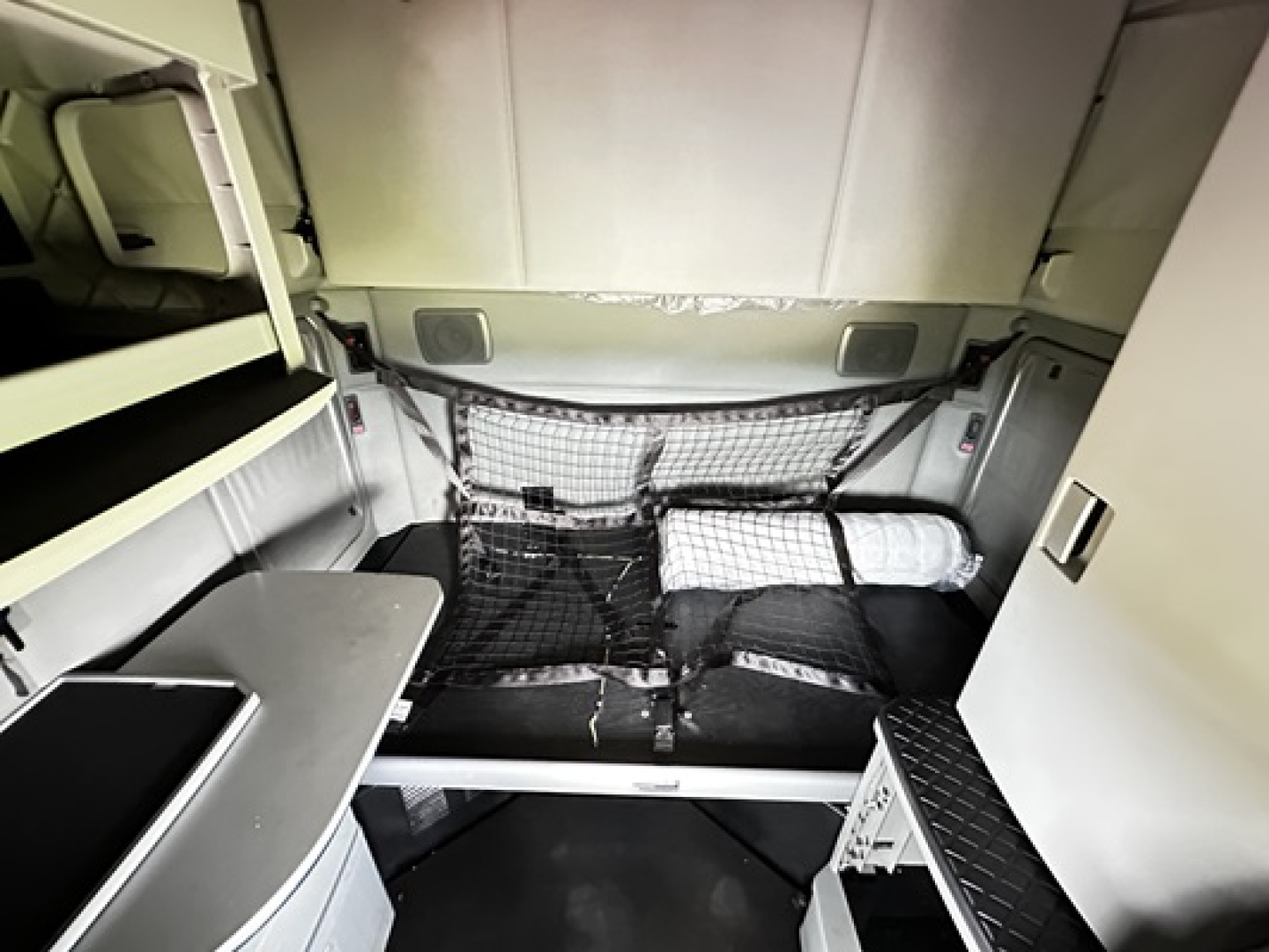 Kenworth T680 sleeper cab interior cargo area with netting and storage shelves visible.