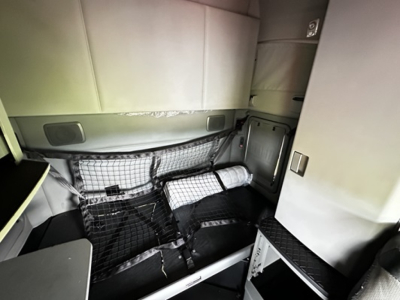 Kenworth T680 sleeper cab interior showing storage nets and side panels.