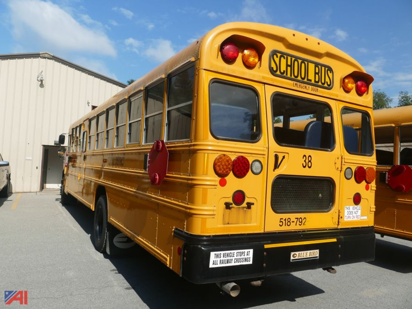 Rear view of a yellow 2016 Blue Bird Vision school bus showing school bus signage and back lights