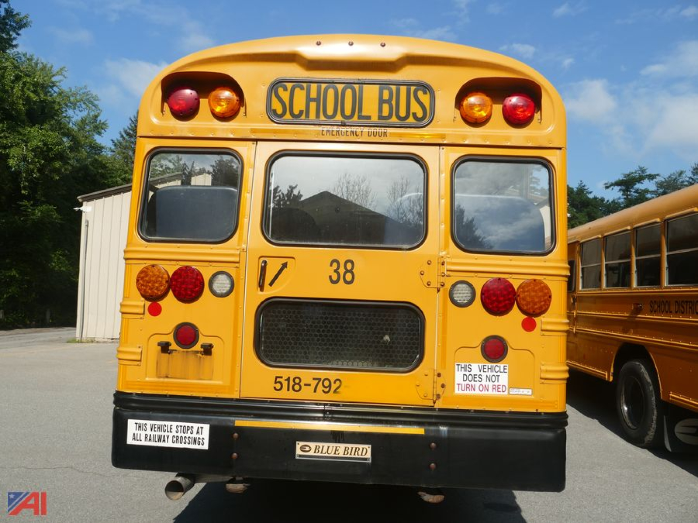 Front/rear view of a 2016 Blue Bird Vision school bus with yellow paint, school bus signage, rear lights, and a numbered 38; license plate area and warnings visible.