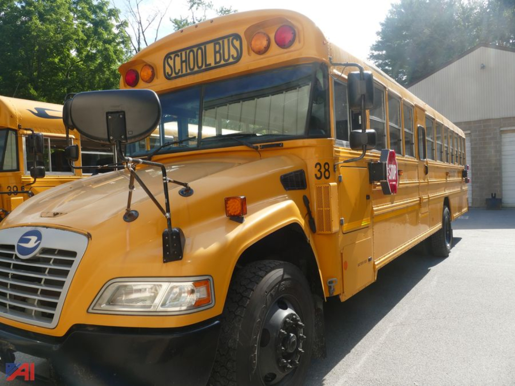 School bus side view showing yellow body, front grille, stop sign, and bus number 38 with 'SCHOOL BUS' sign on top.