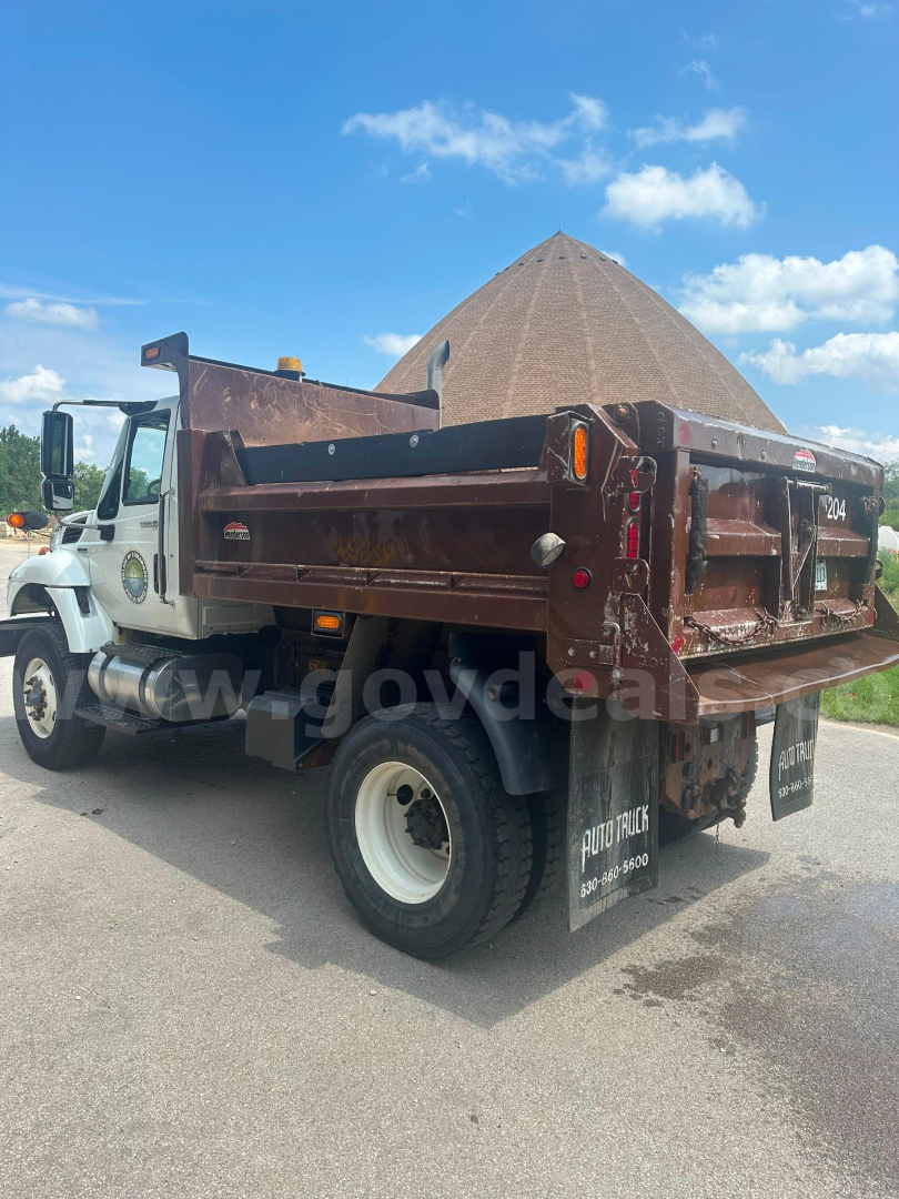 Dump truck 2008 International 7400 in service view showing cargo bed and rear with taillights and bumper.