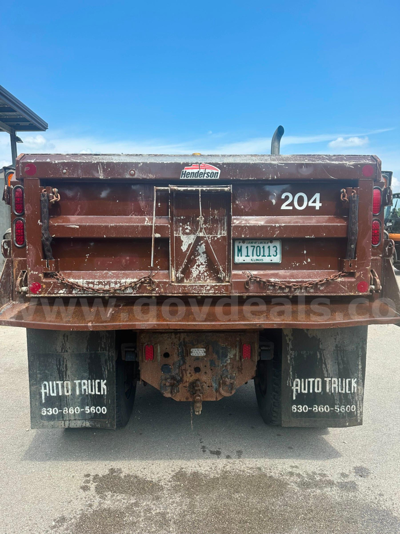 Dump truck rear showing tailgate with number 204, Henderson logo, license plate M170113, mud flaps Auto Truck 630-860-5600, rusty bed, rear underride hitch.
