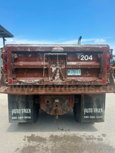 Dump truck rear showing tailgate with number 204, Henderson logo, license plate M170113, mud flaps Auto Truck 630-860-5600, rusty bed, rear underride hitch.