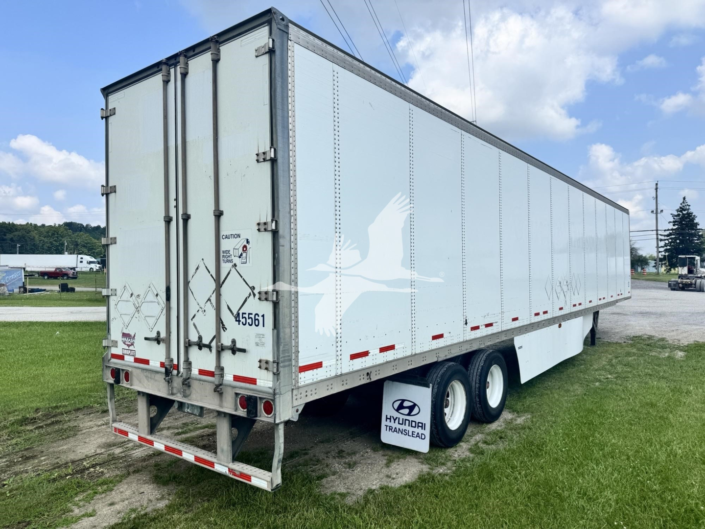 Trailer rear and side view of a 2017 Wabash dry van trailer showing dual rear doors, tandem axles, and white exterior with reflective striping.
