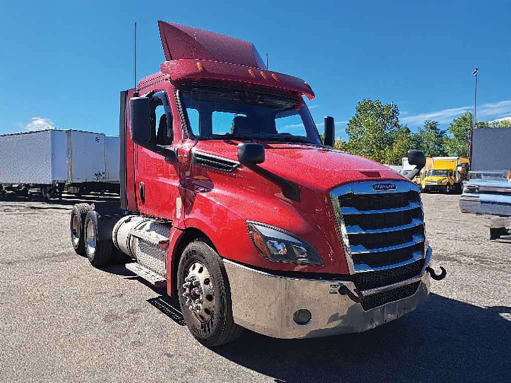 Truck cab showing red Freightliner Cascadia126 day cab with front grille and chrome bumper.