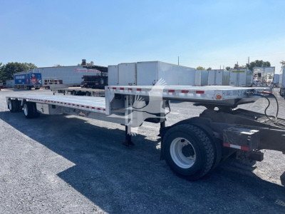 Trailer showing flatbed with dual rear axles and storage boxes on the neck area.