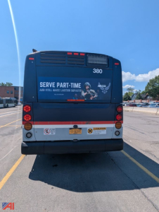 Bus rear view showing XD60 380, bumper, tail lights, and signage reading ‘SERVE PART-TIME’ on a New Flyer transit bus.