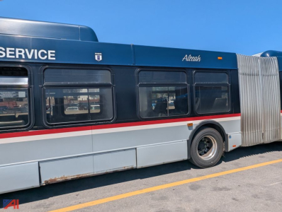 Bus side view showing XD60 transit bus with 'SERVICE' lettering, blue top, white body with red stripe, wheel and accordion cloak visible.