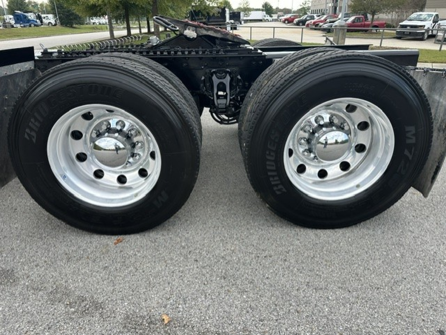 Dual rear tractor tires on a Kenworth truck chassis with polished steel rims and dual wheels, trailer hitch area visible.